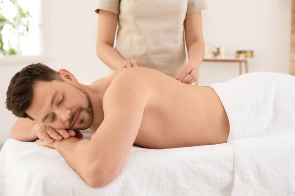 Handsome man receiving back massage in spa salon - Photo, Image
