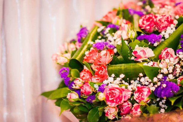 egy csokor rózsaszín, piros és lila virágok világos rózsaszín háttér - Fotó, kép