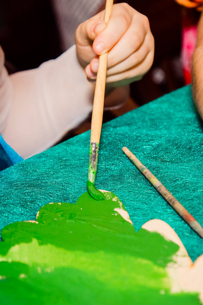 hand of a child painting a Christmas tree with a brush - Photo, Image