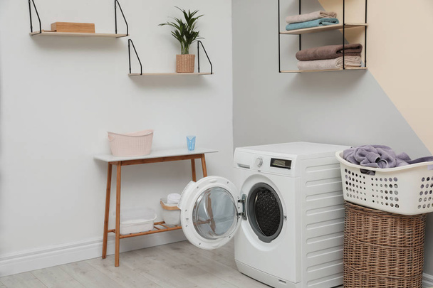 Modern washing machine in laundry room interior - Foto, afbeelding