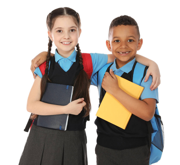 Portrait of cute children in school uniform with books on white background - Фото, изображение