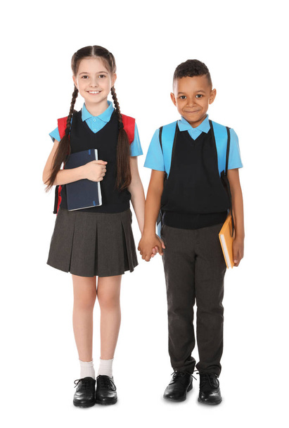 Full length portrait of cute children in school uniform with books on white background - 写真・画像