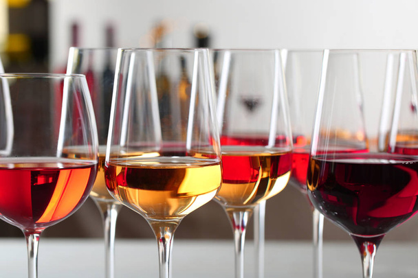 Glasses with different wines on blurred background, closeup - Φωτογραφία, εικόνα
