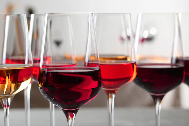 Glasses with different wines on blurred background, closeup - Φωτογραφία, εικόνα