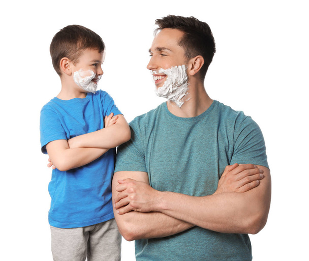 Happy dad and son with shaving foam on faces against white background - Foto, Bild