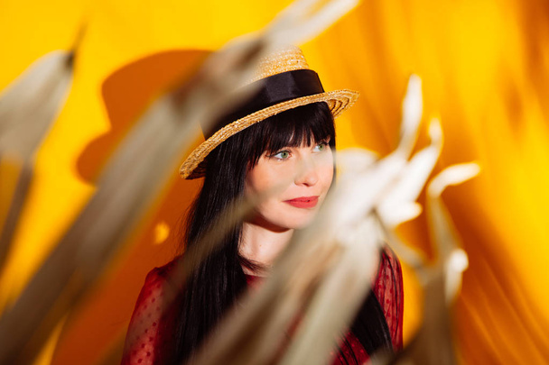 Девушка шляпа солнце светлая тень тропический желтый оранжевый молодой женщины фон красное платье
 - Фото, изображение