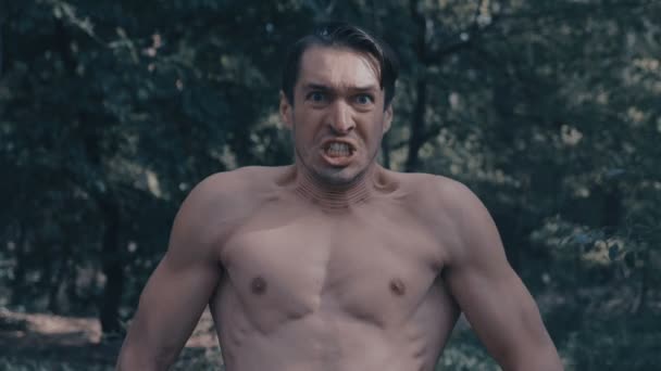 Hombre agresivo con un torso desnudo gritando furiosamente en el bosque
 - Imágenes, Vídeo