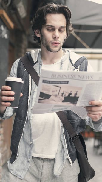 Jeune homme lisant le journal et buvant du café
 - Photo, image