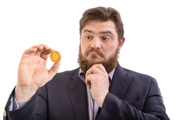 wątpliwe Brodatym biznesmen przedsiębiorca posiadający Bitcoin kryptowaluta, izolowane na białym - Zdjęcie, obraz