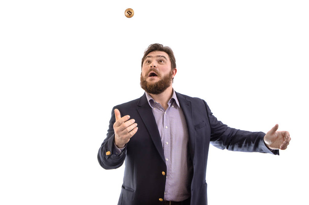 Funny and happy bearded businessman trader tossing gold bitcoin cryptocurrency, isolated on white - Photo, Image