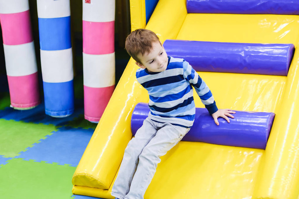 Kids climbing and sliding on outdoor playground. Children play in indoor playground. Amusement center in kindergarten or school yard. Child on colorful slide. Toddler kid. - Fotoğraf, Görsel