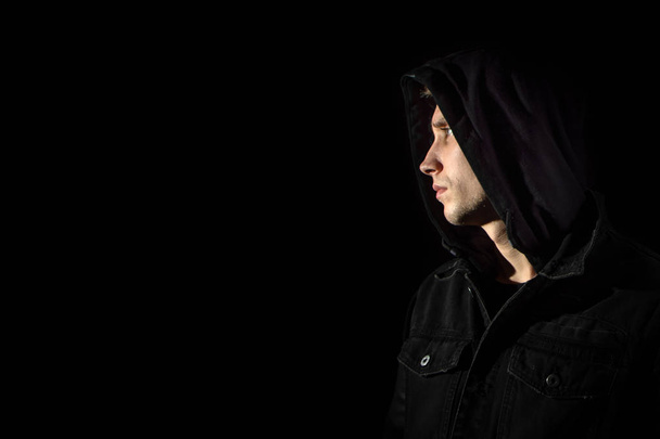 Portrait of a young man in the hood black background - Фото, зображення