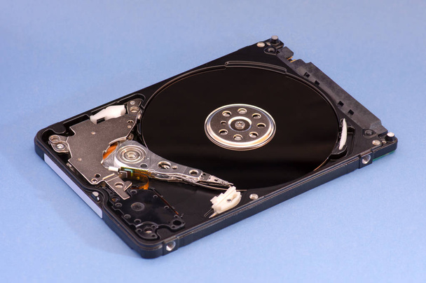 Opened disassembled hard drive from the computer, hdd with mirror effect. on blue background - Photo, Image