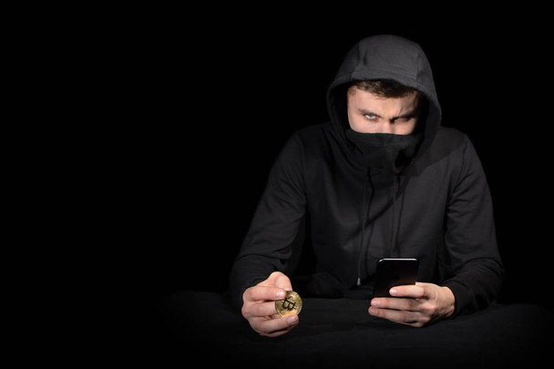 Hacker with mobile phone and bitcoin initiating cyber attack, is - Photo, Image