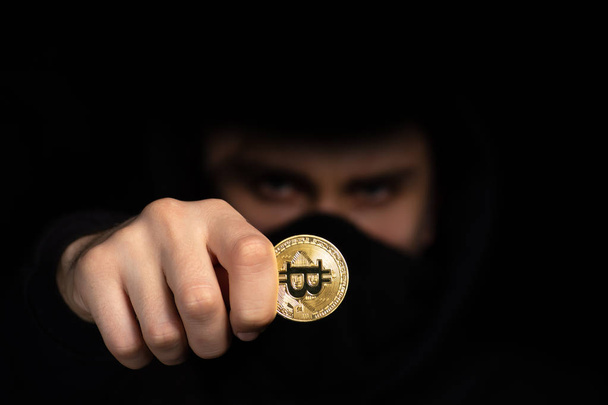Closeup hacker hold bitcoin in hand initiating cyber attack, concept cyber security, isolated on black - Foto, immagini