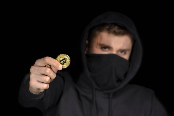 Closeup hacker with blurred face hold bitcoin in hand initiating - Fotoğraf, Görsel