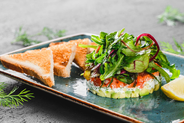 Healthy fresh salad with avocado, salmon, greens, arugula - Фото, зображення