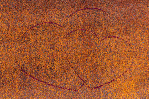 Two drawn hearts on oxide surface close-up. Rust metallic background with two painted hearts. Rust metall with love symbol graffiti. Valentine day image. Unideal iron plane with copy space. - Photo, Image