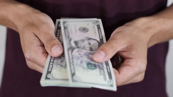 Man casually recounts a pack of dollars in his hands. Money dollars - Video