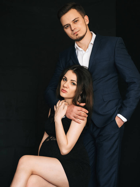 fashionable young married couple posing stylishly. Caucasian man and pregnant woman - Foto, imagen