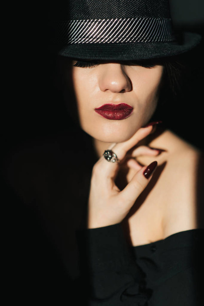 δραματικό πορτρέτο του σέξι νεαρό κορίτσι με μαύρο καπέλο με κόκκινο κραγιόν - Φωτογραφία, εικόνα