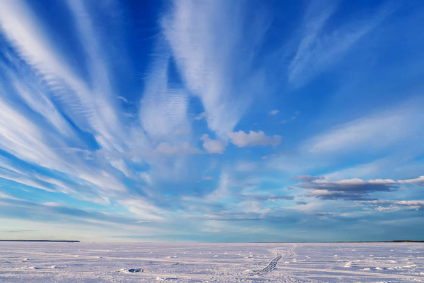 zimní krajina nad zamrzlou řekou s modrou jasnou oblohou a bílými mraky - Fotografie, Obrázek