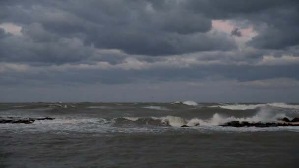 Wind storm in de zee, golven raken rotsen in de regenwolken - Video