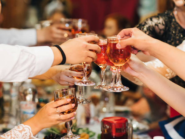 hands of a group of people clinking and toasting glasses of red wine at a festive party in a restaurant - Photo, Image