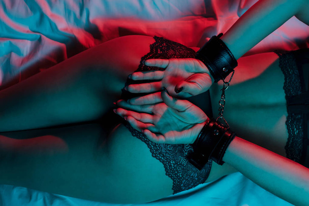 λεία κορίτσι με το προκλητικό σώμα χειροπέδες εσώρουχα στο κρεβάτι - Φωτογραφία, εικόνα