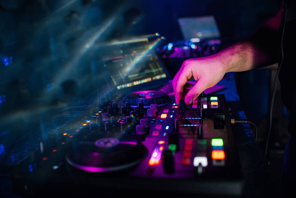 руки DJ воспроизведение и микширование музыки на музыкальный контроллер на вечеринке
 - Фото, изображение