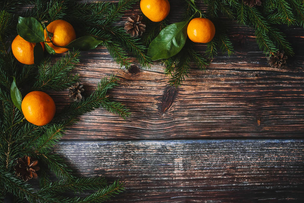 Рождественский фон с мандаринами, еловыми ветвями и конусами. Декоративная зимняя рама
 - Фото, изображение