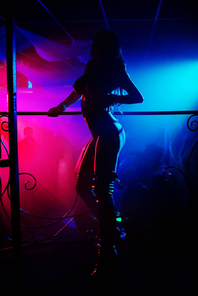 silhueta de uma menina stripper nua com seios grandes em uma boate
 - Foto, Imagem
