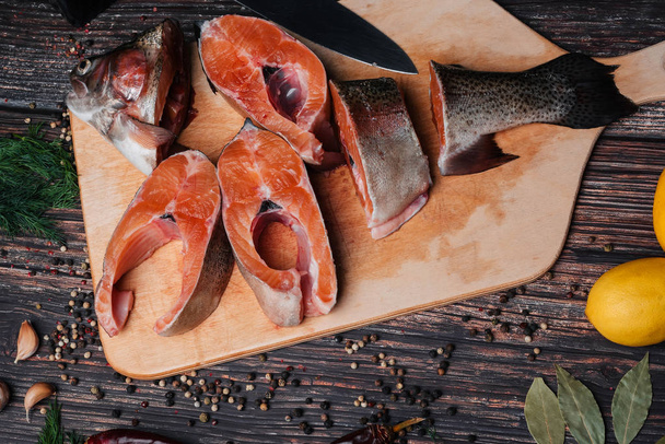cut pieces of trout wooden Board with spices - Фото, изображение