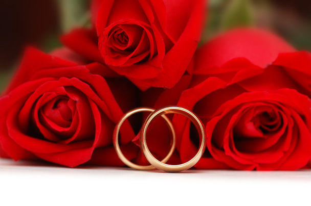 Two gold wedding rings and roses - Foto, afbeelding