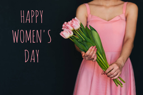 Biglietto di auguri con l'iscrizione Buon giorno delle donne. Bouquet di tulipani rosa nelle mani
 - Foto, immagini