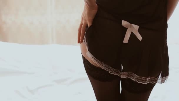 Hizmetçi kostümlü genç bir kız seksi poposunun kalçalarını gösteren bir striptiz gösterisi sergiliyor. Rol yapma oyunları ve erotik fanteziler kavramı - Video, Çekim