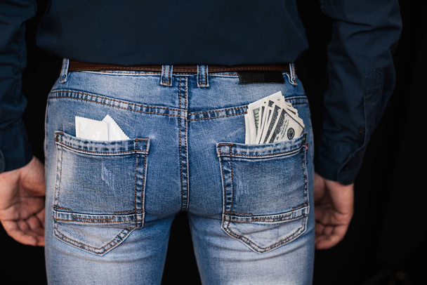 óvszer és bankjegy pénz a hátsó zsebek férfi farmer - Fotó, kép
