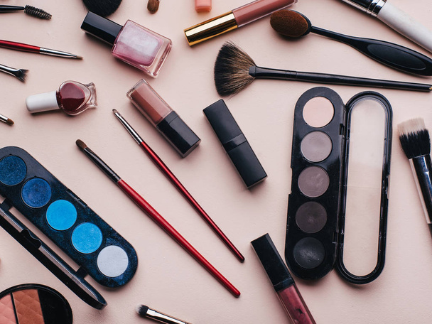 het aantal vrouwelijke cosmetica voor oog make-up, huidverzorging gezicht. Professionele producten voor schoonheid op een roze achtergrond - Foto, afbeelding