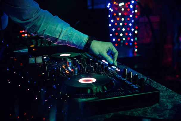DJ παίζει ηλεκτρονική μουσική σε ένα νυχτερινό κέντρο διασκέδασης σε ένα πάρτι - Φωτογραφία, εικόνα