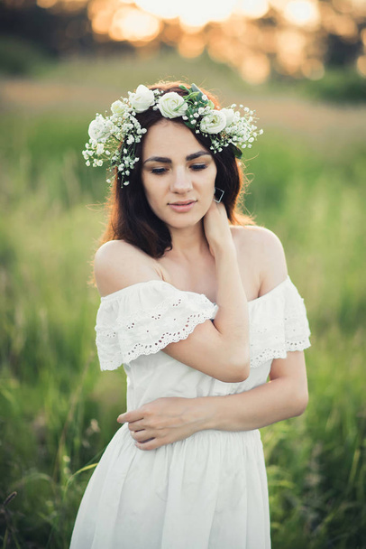 ελκυστική Καυκάσιος μελαχρινή κοπέλα με λευκό φόρεμα και με στεφάνι - Φωτογραφία, εικόνα
