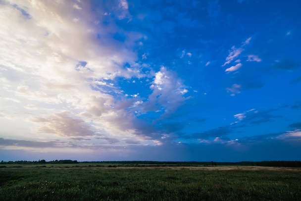 a nyár során a kék felhős ég, hajnalban reggel a réten - Fotó, kép