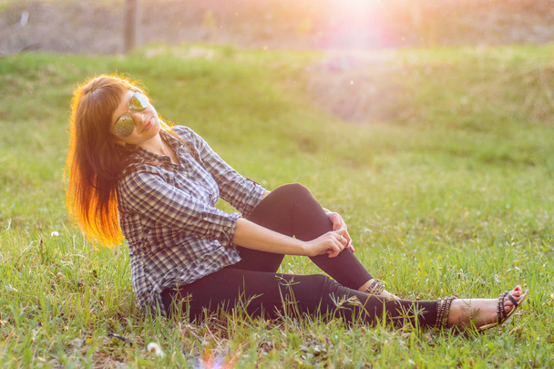 young girl resting on the field at sunset in summer - Foto, imagen