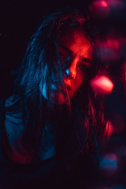 Sensual portrait of sad melancholic lonely girl behind glass with raindrops - Foto, imagen