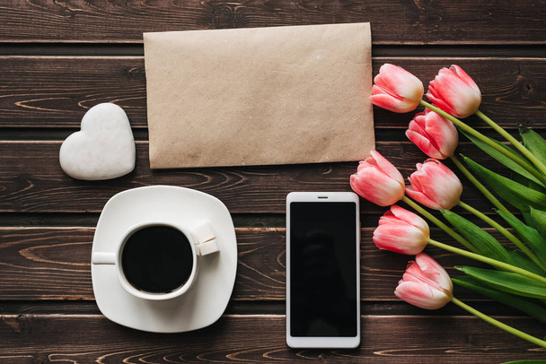 bouquet of pink Tulip flowers with a Cup of coffee and a smartphone for morning Breakfast - Fotoğraf, Görsel