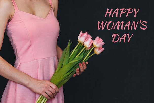 μπουκέτο λουλουδιών από ροζ τουλίπες στα χέρια ενός κοριτσιού. Ευχετήρια κάρτα με κείμενο χαρούμενη ημέρα της γυναίκας - Φωτογραφία, εικόνα
