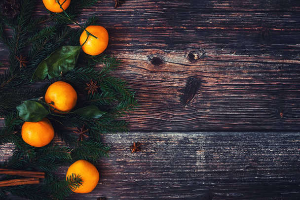 Vánoční pozadí s mandarinky, větve jedle a šišky. Zimní dovolená rám s skořicí, badyánem a kopírovat prostoru. Plochá laický pohled shora - Fotografie, Obrázek