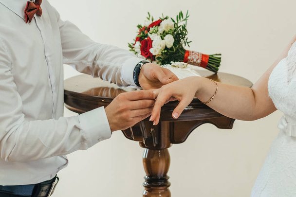 novio pone un anillo de bodas de oro en el dedo de la novia - Foto, imagen