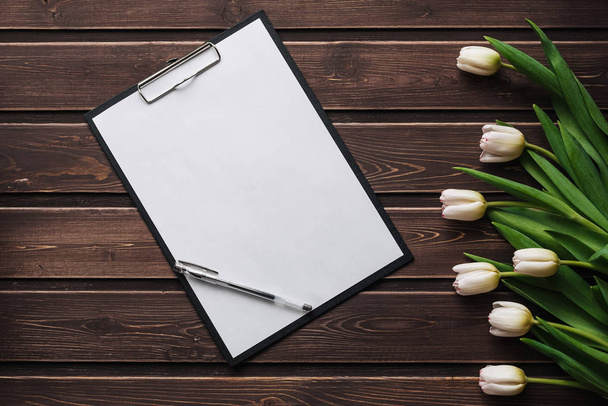 Tulipes blanches sur une table en bois avec une tablette en papier vide. Carte de vœux vierge pour la Saint Valentin
 - Photo, image