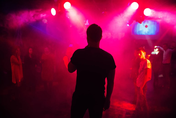 silueta del cantante contra una multitud de personas en una fiesta en un club nocturno
 - Foto, imagen