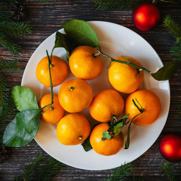 Fondo natalizio con mandarini, rami di abete, palline rosse. Decorazione invernale festiva tradizionale per il nuovo anno
 - Foto, immagini